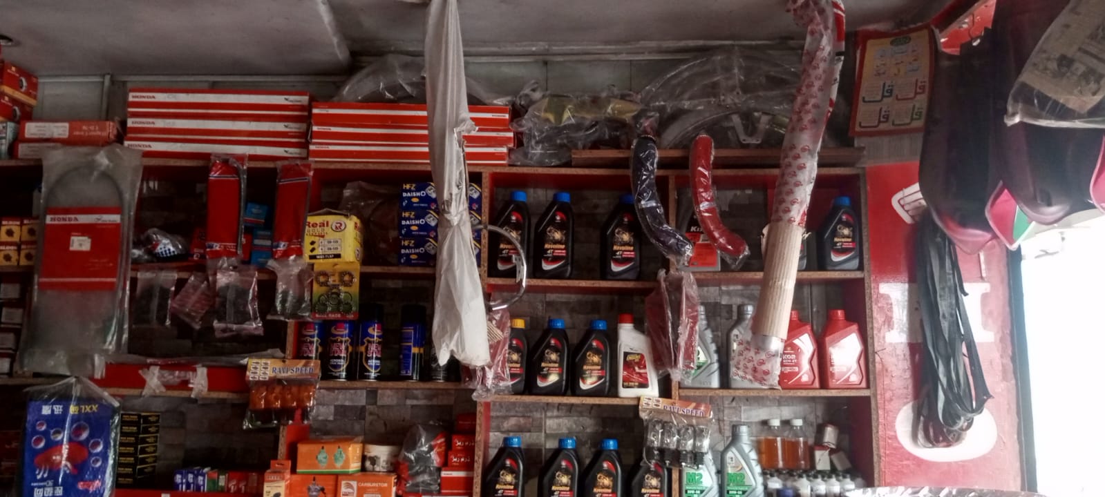Wide view of spare parts shelves with oils and Honda parts